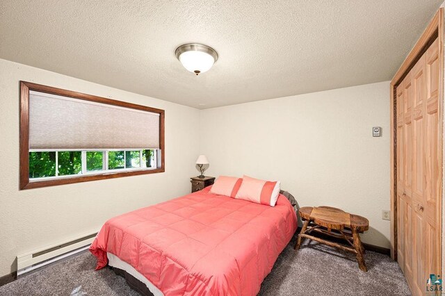 carpeted bedroom featuring a baseboard radiator, a textured ceiling, and baseboards
