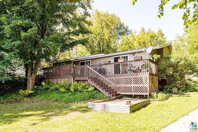 rear view of house featuring a yard and a deck