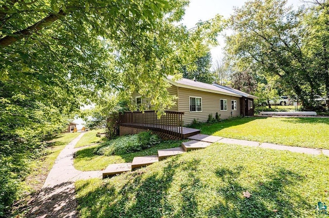 view of green lawn with a wooden deck