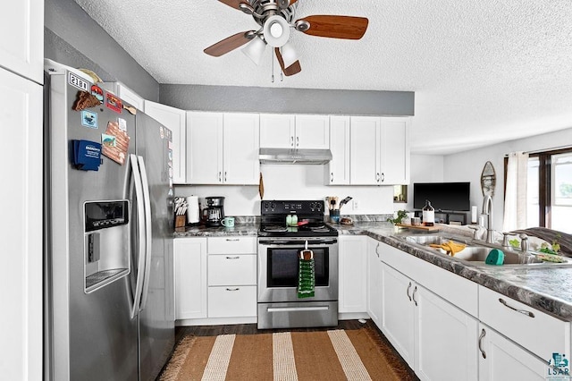 kitchen with stainless steel appliances, under cabinet range hood, a sink, a textured ceiling, and white cabinetry
