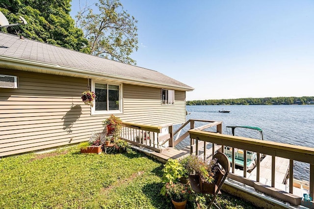 wooden deck featuring a water view and a lawn