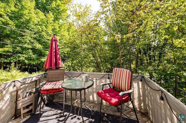 wooden terrace featuring a wooded view