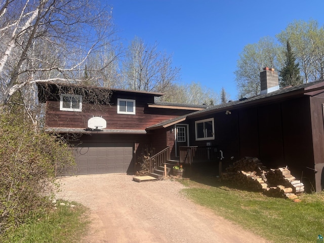 5346 Lester River Rd, Duluth, MN 55804 - split level home with dirt driveway, a chimney, and a garage