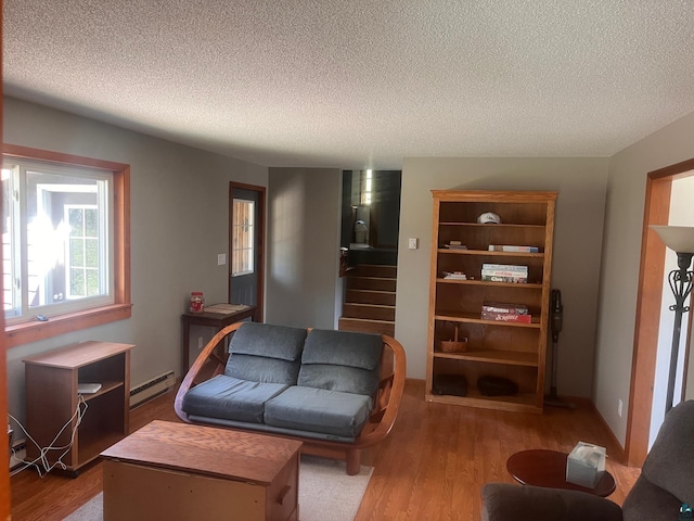 5346 Lester River Rd, Duluth, MN 55804 - living area featuring baseboard heating, wood finished floors, a textured ceiling, and stairs