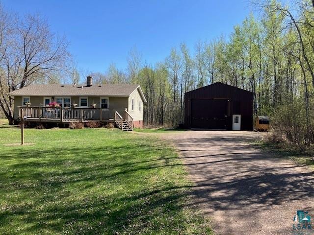 5882 W Marigold Ln, Esko, MN 55733 - view of front of house with a garage, an outbuilding, a deck, dirt driveway, and a front yard