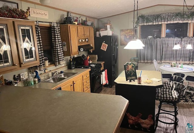 kitchen featuring a sink, dark wood finished floors, crown molding, exhaust hood, and black appliances