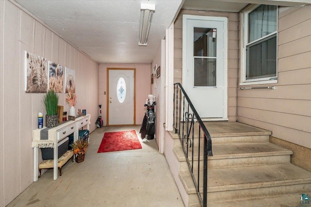 304 Carlton Ave, Cloquet, MN 55720 - entrance foyer with wooden walls, stairs, and concrete flooring