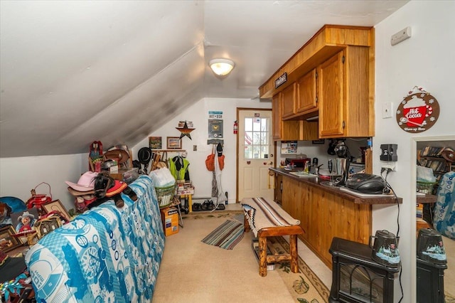 304 Carlton Ave, Cloquet, MN 55720 - kitchen with vaulted ceiling, brown cabinets, light colored carpet, and dark countertops