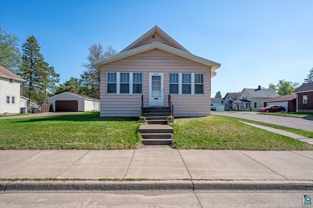 304 Carlton Ave, Cloquet, MN 55720 - view of front facade with a detached garage, a front yard, and an outbuilding