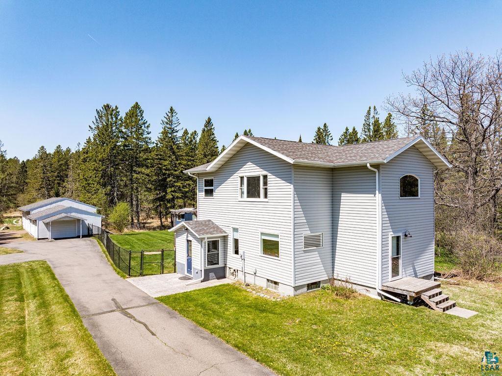5465 Arnold Rd, Duluth, MN 55803 - traditional home featuring a detached garage, a shingled roof, and an outdoor structure