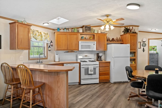 10412 Lakeside Dr, Finlayson, MN 55735 - kitchen featuring white appliances, a sink, ornamental molding, a skylight, and a peninsula