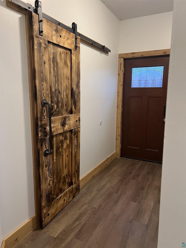 7789 Jokela Rd, Cloquet, MN 55720 - doorway with a barn door, wood finished floors, and baseboards