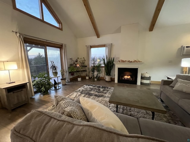7789 Jokela Rd, Cloquet, MN 55720 - living area featuring high vaulted ceiling, beam ceiling, a lit fireplace, wood finished floors, and a wall mounted AC