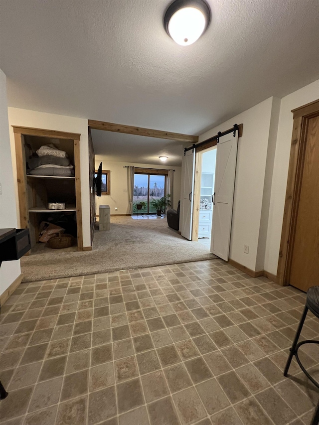 7789 Jokela Rd, Cloquet, MN 55720 - unfurnished living room with a textured ceiling, baseboards, and a barn door