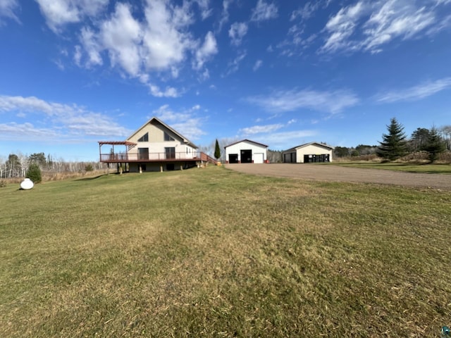 7789 Jokela Rd, Cloquet, MN 55720 - view of grassy yard featuring asphalt driveway, an outbuilding, a deck, and a garage