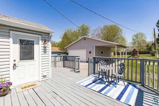 426 22nd St, Cloquet, MN 55720 - wooden deck featuring an outbuilding, a garage, a lawn, and a playground