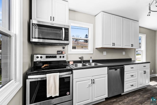426 22nd St, Cloquet, MN 55720 - kitchen featuring appliances with stainless steel finishes, a sink, dark countertops, and white cabinetry