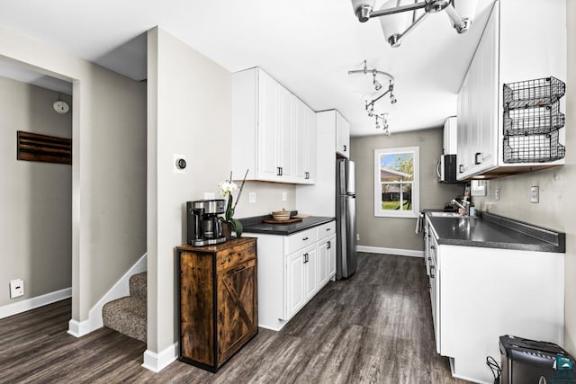 426 22nd St, Cloquet, MN 55720 - kitchen with appliances with stainless steel finishes, dark countertops, dark wood-style floors, and white cabinets