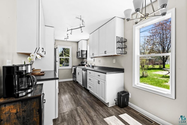 426 22nd St, Cloquet, MN 55720 - kitchen with stainless steel appliances, dark countertops, dark wood-type flooring, and baseboards