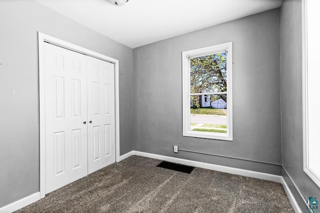426 22nd St, Cloquet, MN 55720 - unfurnished bedroom featuring dark carpet, multiple windows, and a closet