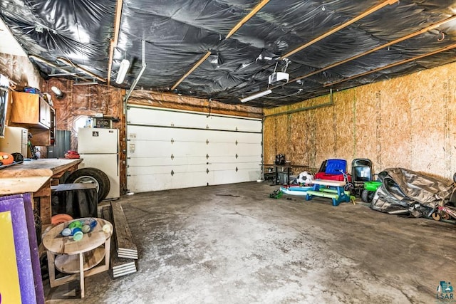 426 22nd St, Cloquet, MN 55720 - garage featuring freestanding refrigerator and a garage door opener