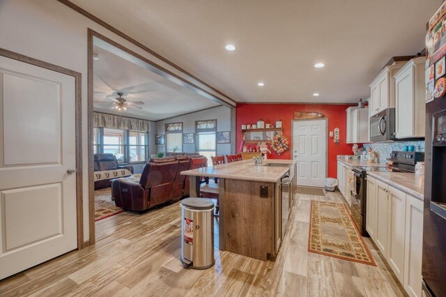 10173 Little Marais Trl, Silver Bay, MN 55614 - kitchen featuring black electric range oven, stainless steel microwave, white cabinetry, light countertops, and a center island