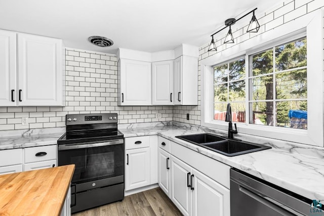 2106 Piedmont Ave, Duluth, MN 55811 - kitchen with range with electric cooktop, stainless steel dishwasher, a sink, and decorative backsplash