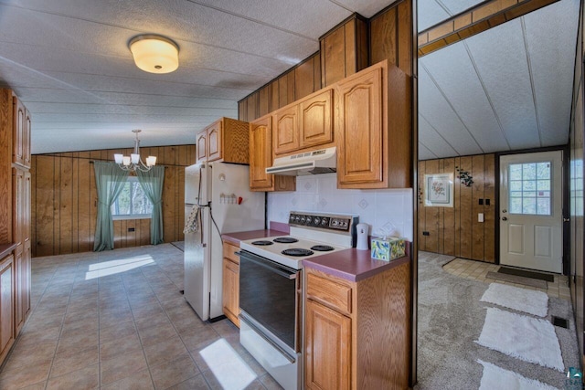 4538 Bass Lake Rd, Gilbert, MN 55741 - kitchen with white appliances, under cabinet range hood, wood walls, a chandelier, and decorative light fixtures