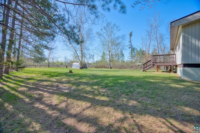 4538 Bass Lake Rd, Gilbert, MN 55741 - view of green lawn featuring stairway, a wooden deck, a storage unit, and an outdoor structure