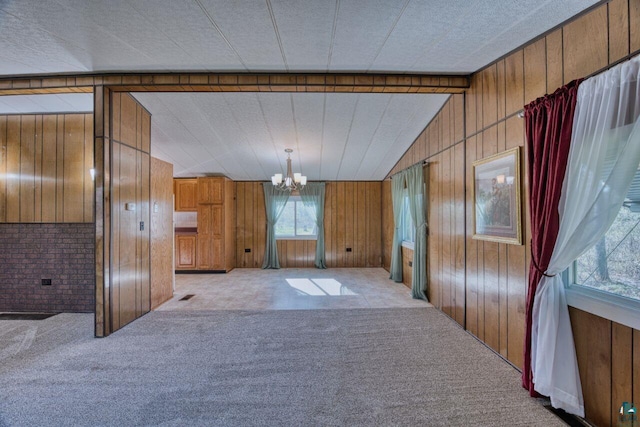 4538 Bass Lake Rd, Gilbert, MN 55741 - unfurnished dining area featuring a chandelier, lofted ceiling, carpet, and wooden walls