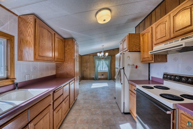4538 Bass Lake Rd, Gilbert, MN 55741 - kitchen with white appliances, under cabinet range hood, a chandelier, brown cabinets, and vaulted ceiling