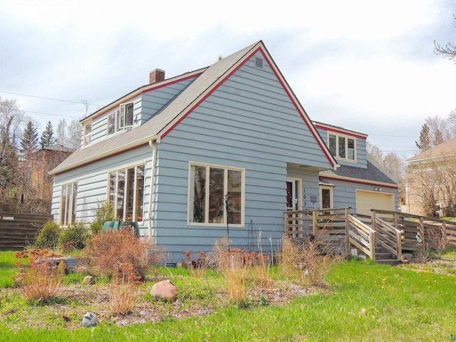 103 3rd Ave W, Grand Marais, MN 55604 - rear view of house with a chimney, a garage, and roof with shingles