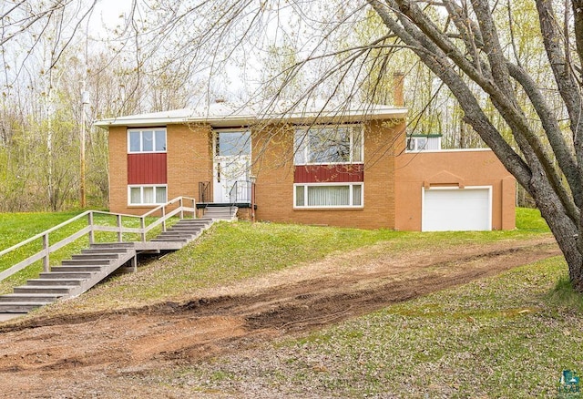 3026 Getchell Rd, Duluth, MN 55810 - split foyer home featuring brick siding, a front lawn, an attached garage, and dirt driveway