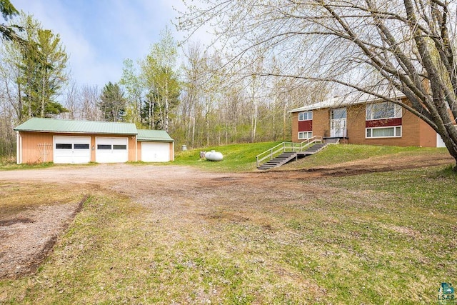 3026 Getchell Rd, Duluth, MN 55810 - view of green lawn featuring dirt driveway, a detached garage, and an outdoor structure