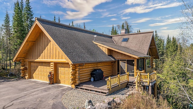 693 Kawishiwi Trl, Ely, MN 55731 - log home with log siding, a sunroom, roof with shingles, and a deck