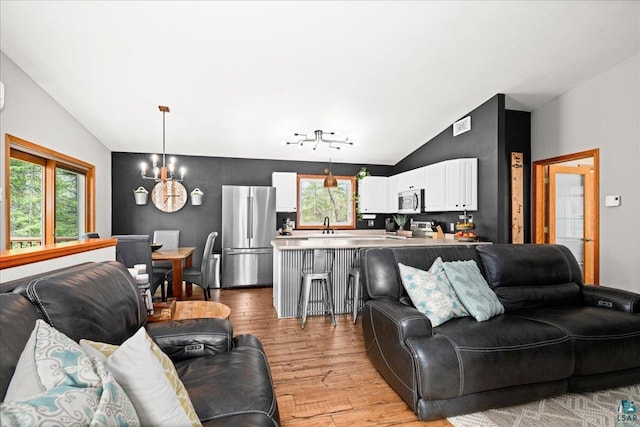 25 Maki Rd, Esko, MN 55733 - living area featuring vaulted ceiling, a chandelier, and light wood-style floors