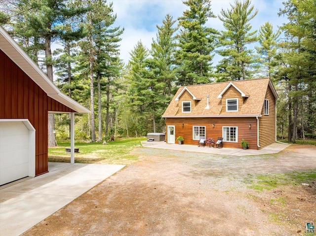 25 Maki Rd, Esko, MN 55733 - view of property exterior featuring a shingled roof, driveway, and a garage
