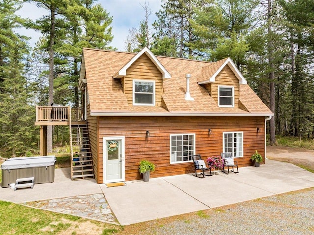25 Maki Rd, Esko, MN 55733 - back of property with a hot tub, stairs, a patio area, roof with shingles, and a wooden deck