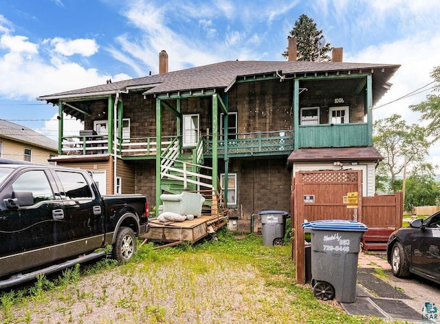 1006 87th Ave W Uppe, Unit Uppe, Duluth, MN 55808 - view of front facade with a chimney, stone siding, stairway, and a shingled roof