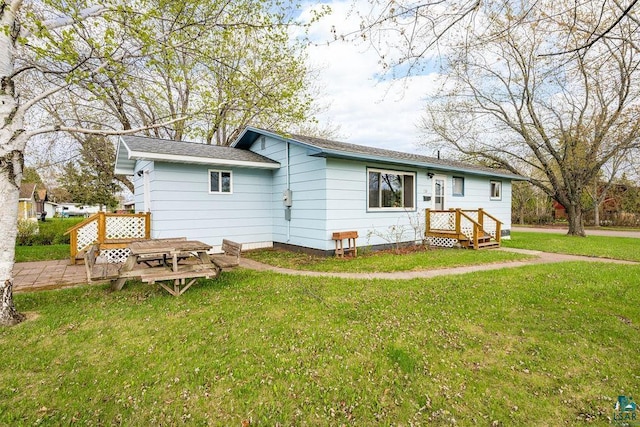 733 13th Ave, Two Harbors, MN 55616 - rear view of property with a lawn and roof with shingles