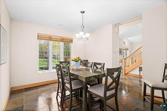 203 S 2nd Ave, Proctor, MN 55810 - dining area with baseboards, stone tile floors, a chandelier, and stairs