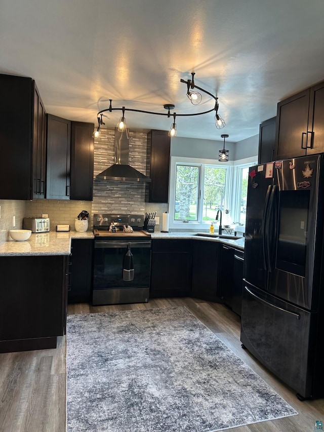 706 28th St, Cloquet, MN 55720 - kitchen featuring electric range, black refrigerator with ice dispenser, wall chimney range hood, a sink, and light wood finished floors