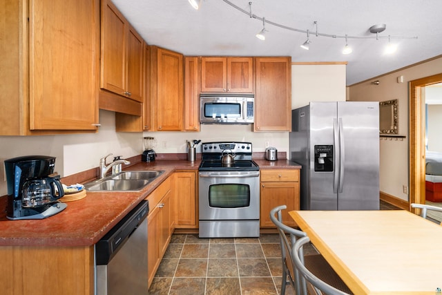 21 E Wisconsin St Unit 301, Grand Marais, MN 55616 - kitchen with appliances with stainless steel finishes, a sink, stone finish floors, brown cabinetry, and dark countertops