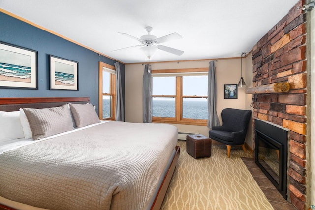 21 E Wisconsin St Unit 301, Grand Marais, MN 55616 - bedroom with a baseboard radiator, a water view, a ceiling fan, and a fireplace