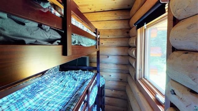 109 Tom Overlook Trl, Hovland, MN 55606 - unfurnished bedroom featuring log walls, multiple windows, and wood ceiling