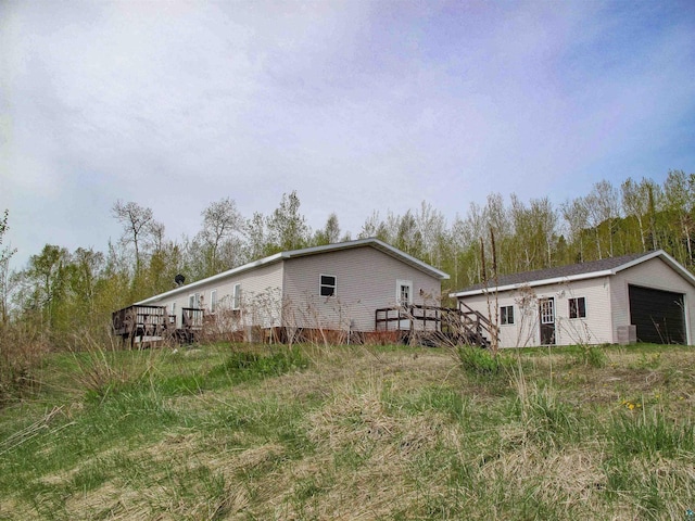 296 Cramer Rd, Schroeder, MN 55613 - view of home's exterior with a wooden deck, an outbuilding, and a detached garage