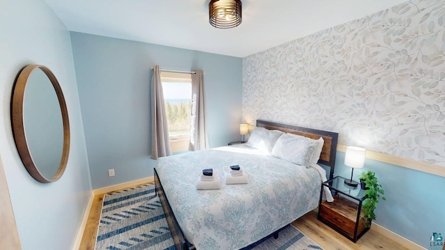 296 Cramer Rd, Schroeder, MN 55613 - bedroom featuring wallpapered walls, wood finished floors, and baseboards