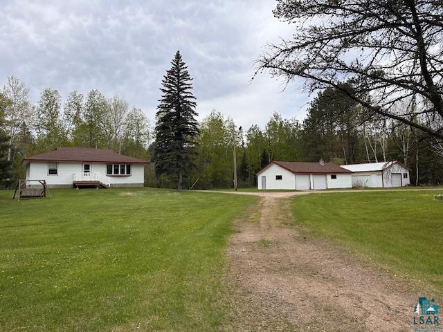 5960 Evergreen Rd, Aurora, MN 55705 - view of grassy yard with driveway, a detached garage, and a deck