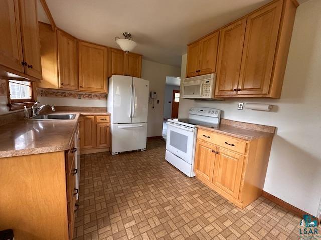 5960 Evergreen Rd, Aurora, MN 55705 - kitchen featuring white appliances, baseboards, a sink, and brick patterned flooring