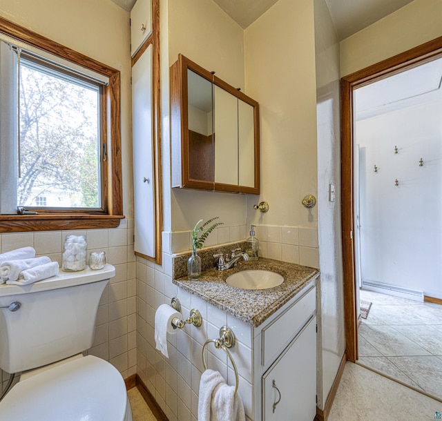 405 10th Ave, Two Harbors, MN 55616 - bathroom featuring toilet, vanity, tile patterned floors, and tile walls